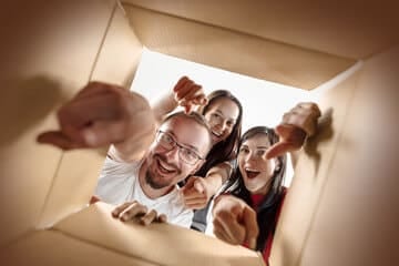 famiglia felice che guarda all'interno di uno scatolone