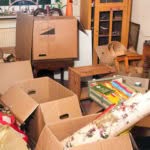 scatoloni e oggetti vari accatastati pronti per lo sgombero